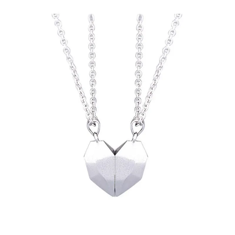 Gold-plated magnetic faceted heart pendant necklace in black and white on display