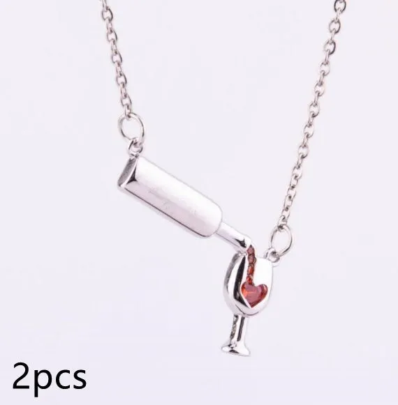 Gold alloy wine bottle and glass pendant necklace on a light background
