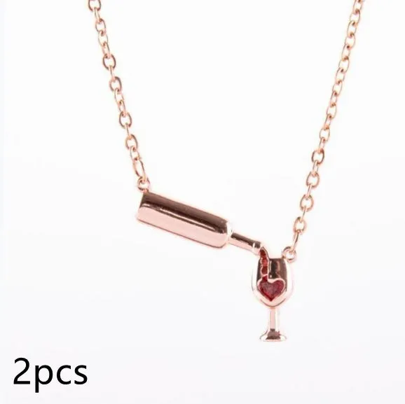 Gold alloy wine bottle and glass pendant necklace on a light background