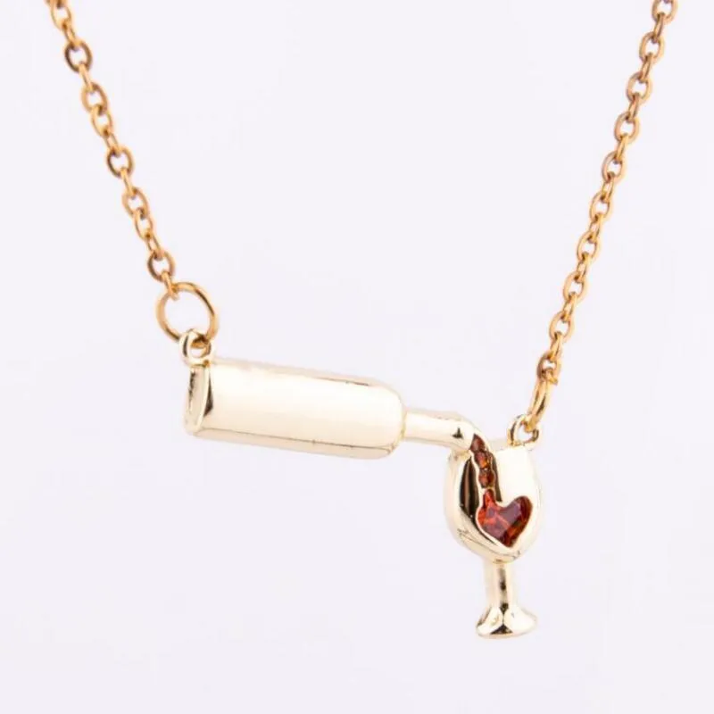 Gold alloy wine bottle and glass pendant necklace on a light background