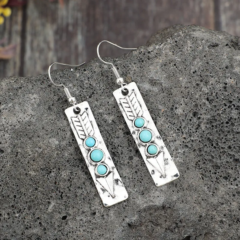 Silver geometric earrings with turquoise detail on white background