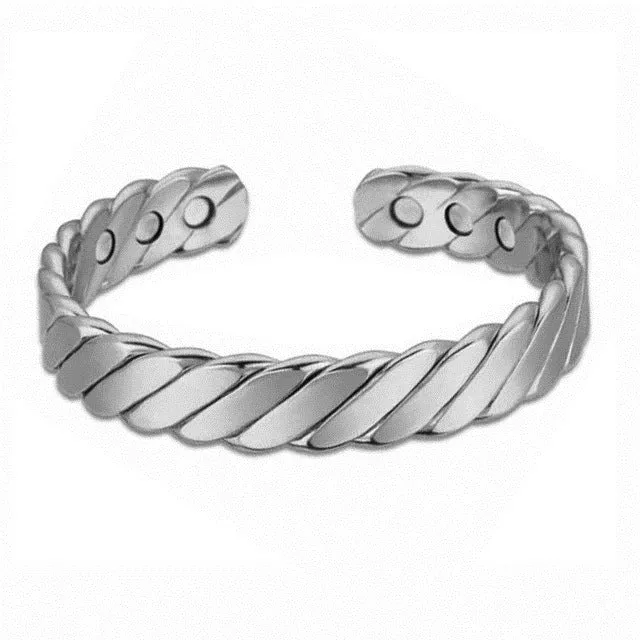 Silver tone metal bracelet on a flat surface, unisex design for men women children