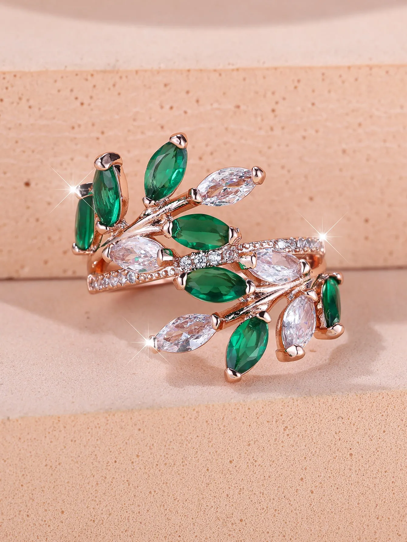 Adjustable copper leaf fashion ring with a central zircon stone on a model's hand, showing rose gold and platinum colour variants.