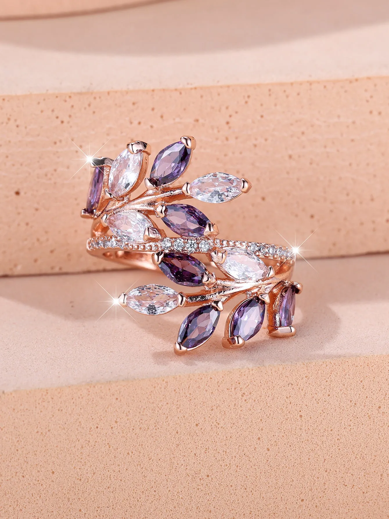 Adjustable copper leaf fashion ring with a central zircon stone on a model's hand, showing rose gold and platinum colour variants.