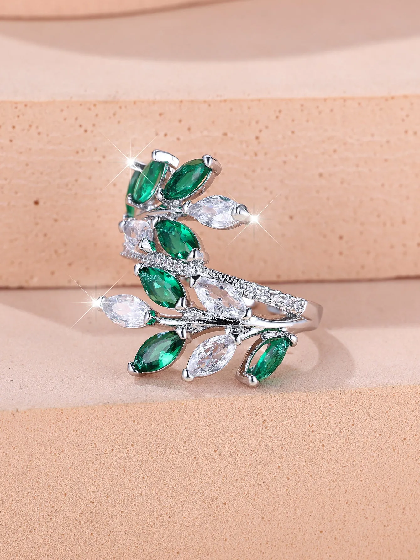 Adjustable copper leaf fashion ring with a central zircon stone on a model's hand, showing rose gold and platinum colour variants.