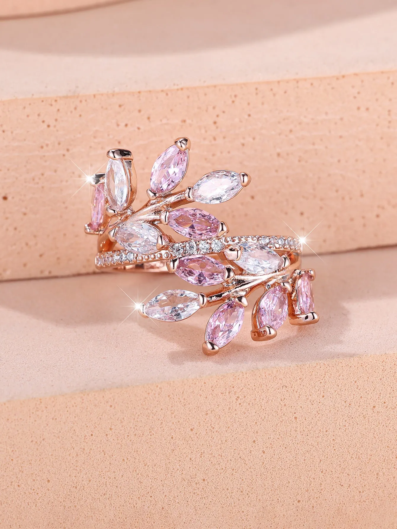 Adjustable copper leaf fashion ring with a central zircon stone on a model's hand, showing rose gold and platinum colour variants.