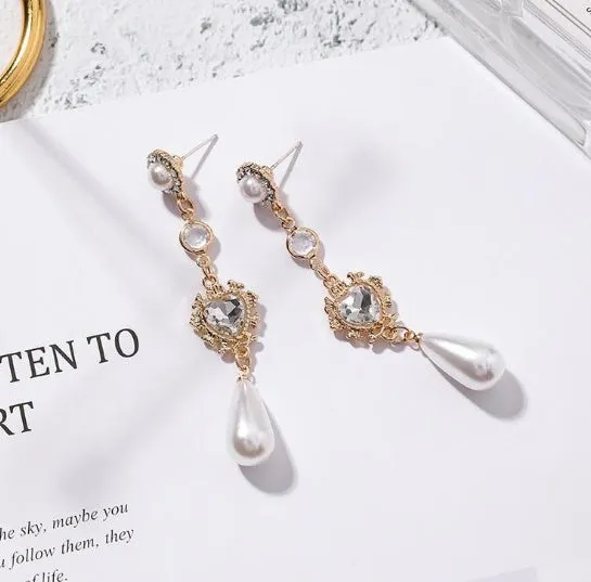 Gold pearl drop earrings with heart-shaped alloy frame and single pearl pendant on gold-tone finish