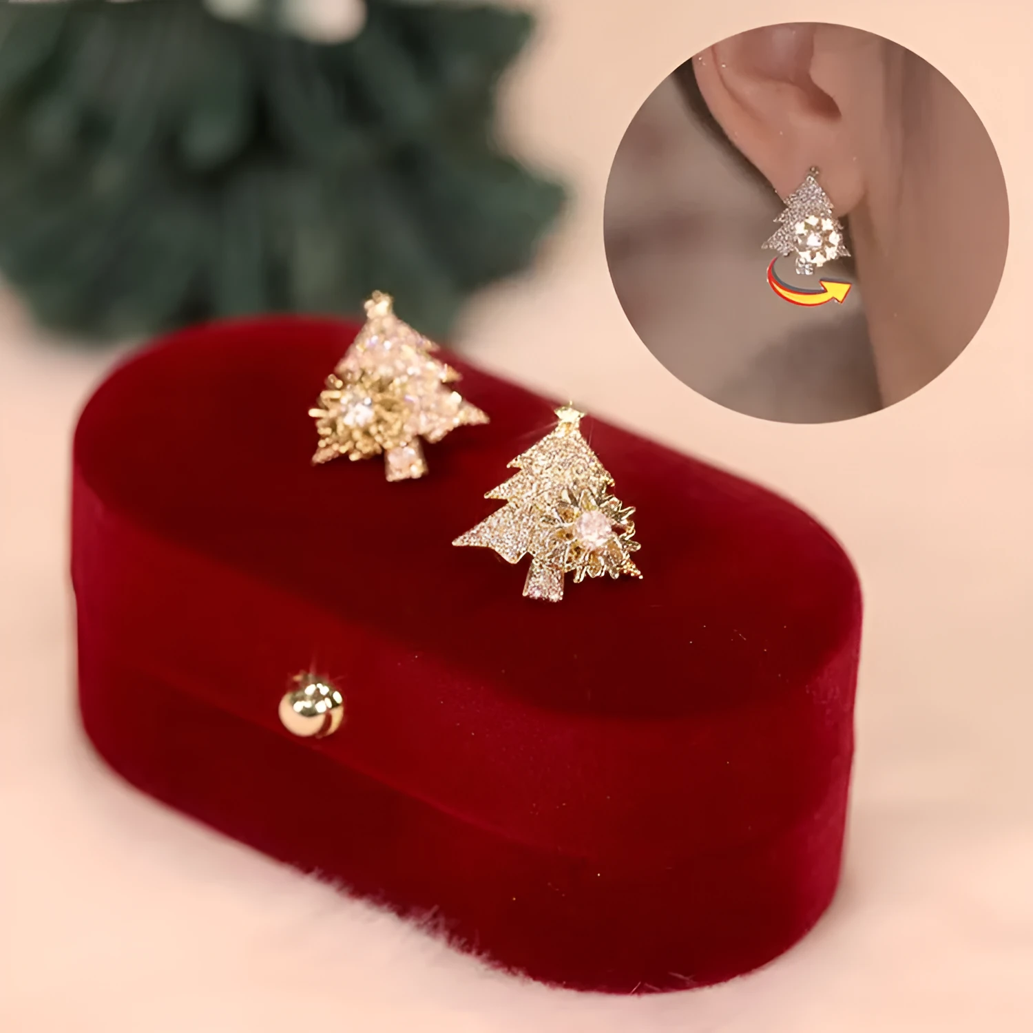 Pair of rotatable Christmas tree stud earrings with rhinestone snowflake detail in gold on a white background