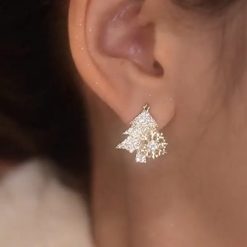 Pair of rotatable Christmas tree stud earrings with rhinestone snowflake detail in gold on a white background