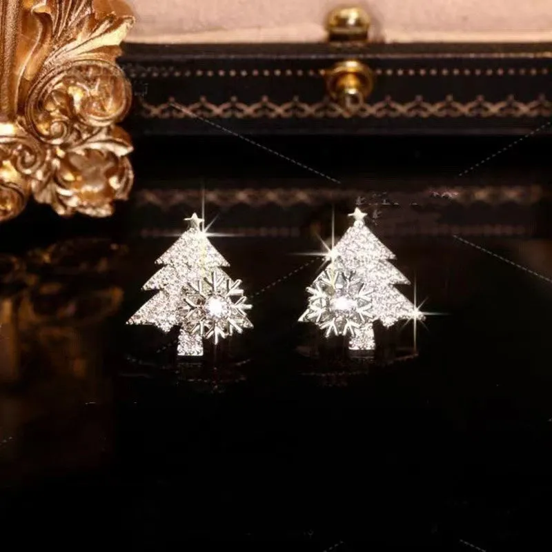 Pair of rotatable Christmas tree stud earrings with rhinestone snowflake detail in gold on a white background