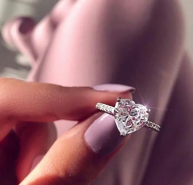 White gold alloy heart-shaped ring with AAA zircon stone on a light background