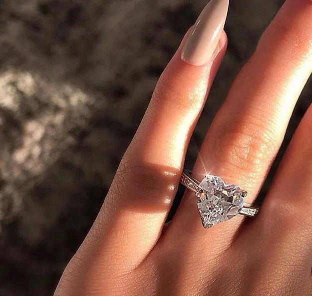 White gold alloy heart-shaped ring with AAA zircon stone on a light background
