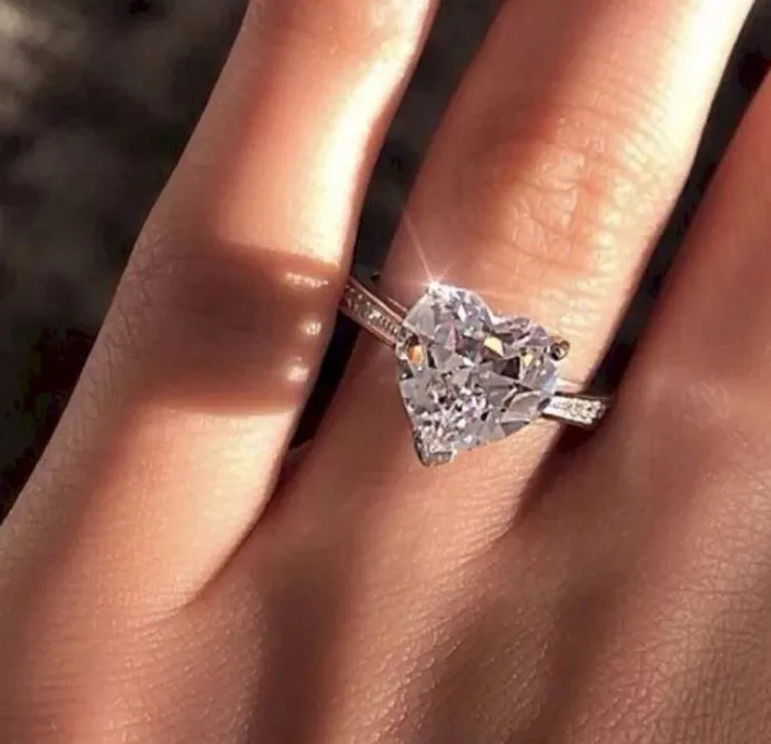 White gold alloy heart-shaped ring with AAA zircon stone on a light background