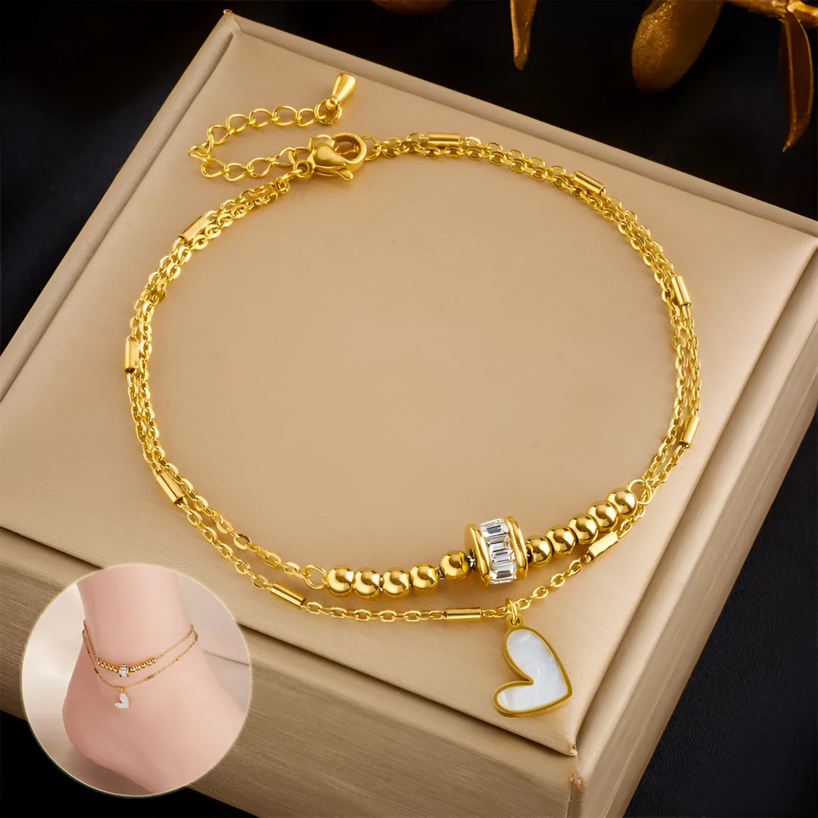 Gold titanium steel double-layer ankle chain with love heart charm and tassel on a white background