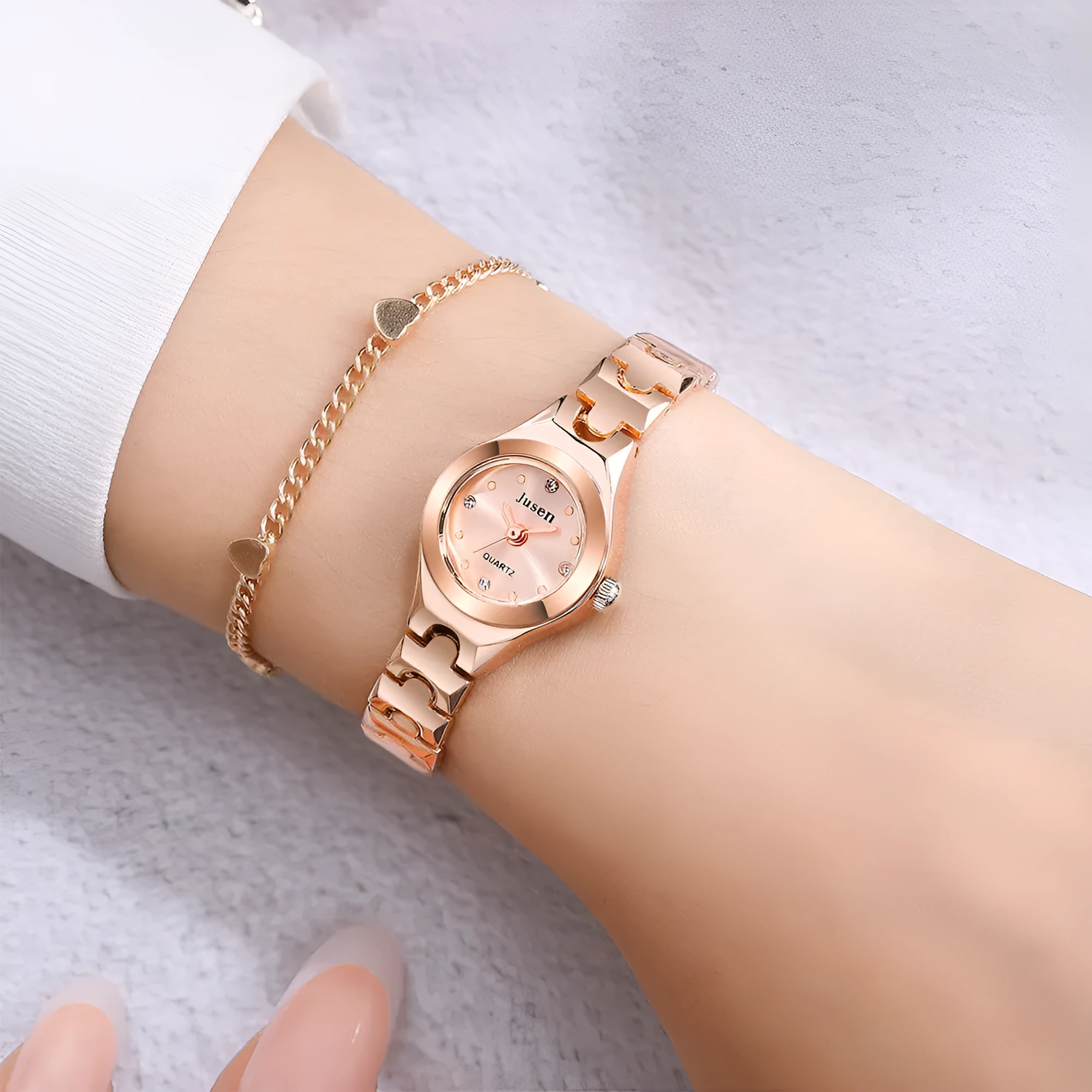 Small round ladies quartz watch with alloy bracelet and gold-tone finish on white background