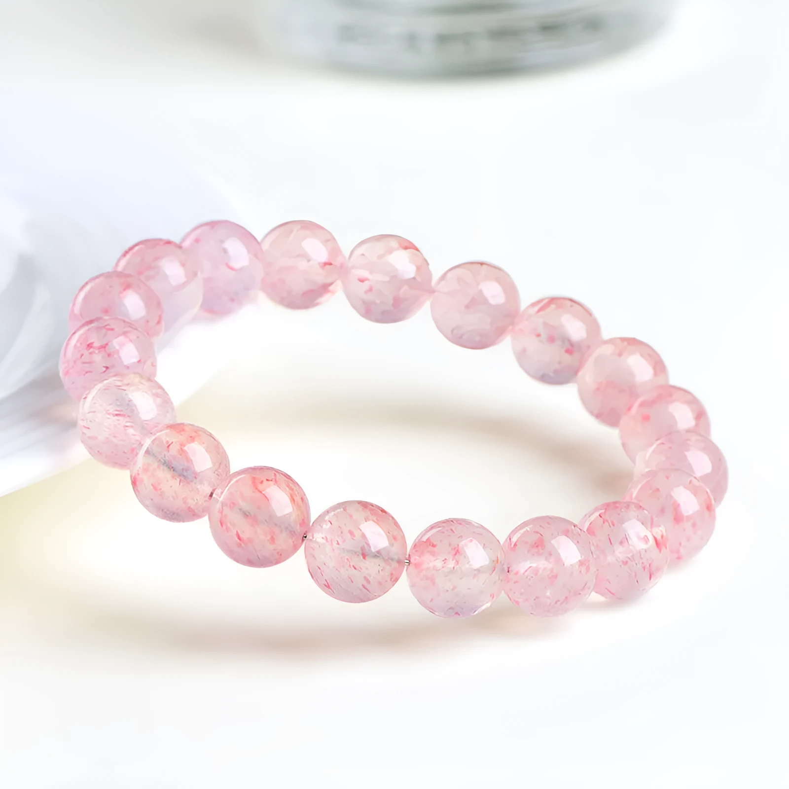 Natural strawberry quartz crystal bracelet with white water geometric beads on elastic cord.