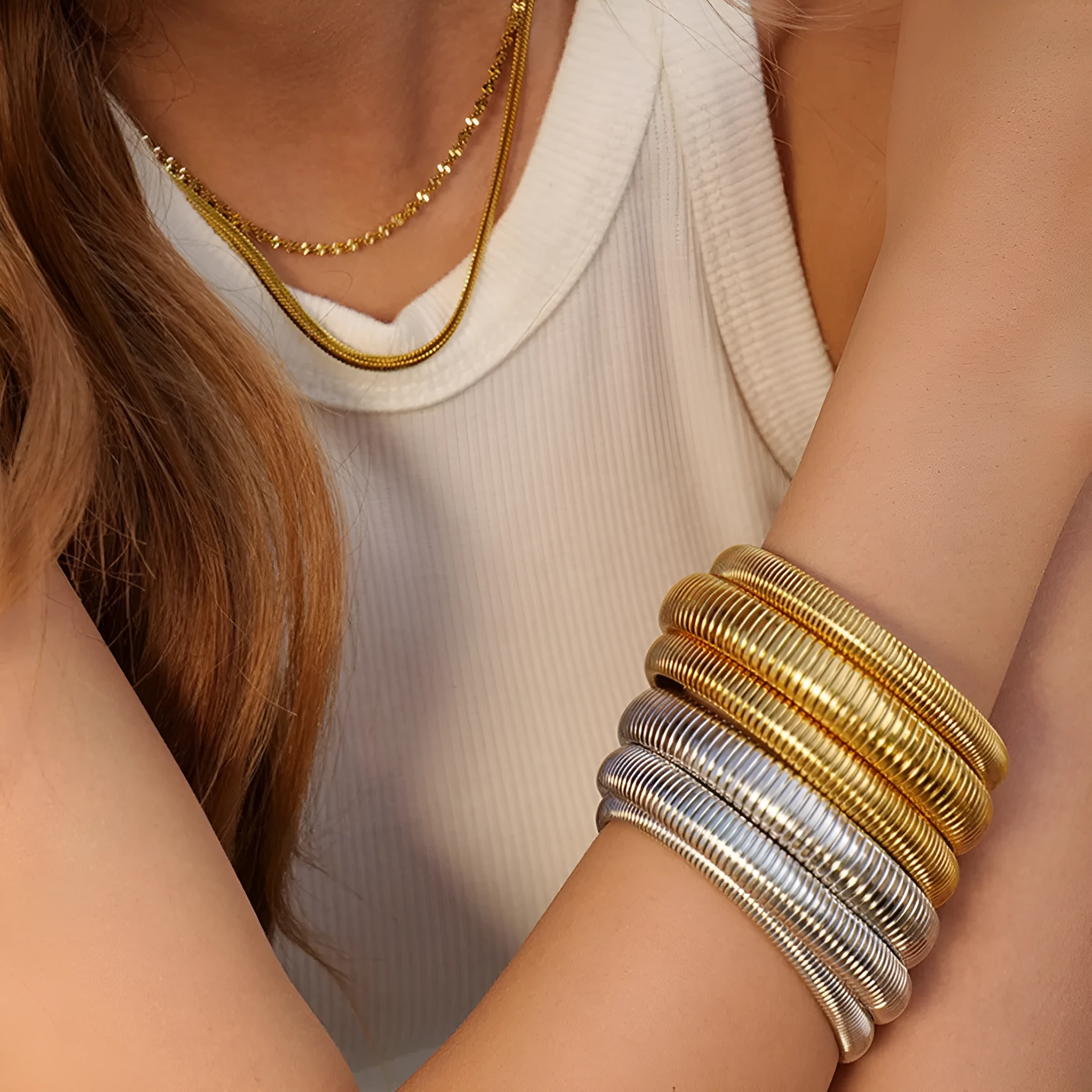 Gold women's elastic bracelet with a wide vertical stripe pattern, shown on a wrist.
