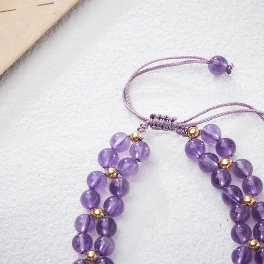 Handmade purple amethyst crystal bracelet with multi-treasure natural stone beads on white background