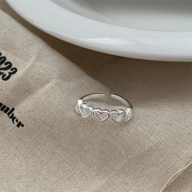 Adjustable copper love heart-shaped ring with electroplated finish on white background