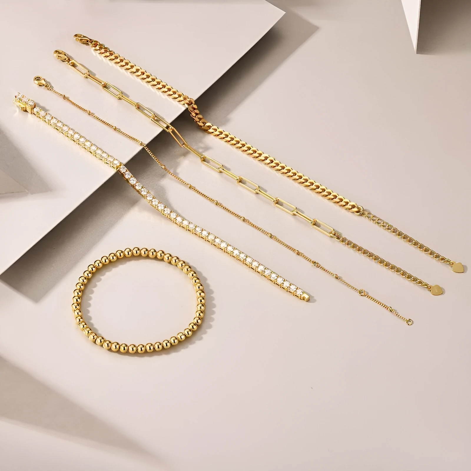 Five stacked S925 silver gold bracelets with round moissanite stones in geometric mosaic design on white background