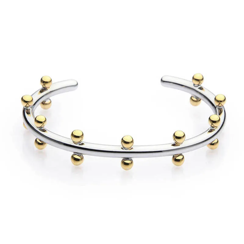 Stainless steel C-shaped bean beads with textured rivet design in gold, steel, and steel gold colours next to an alloy bracelet.