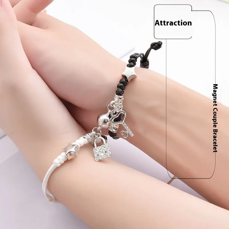 Pair of magnetic alloy bracelets with crown and heart charm designs on a wrist.