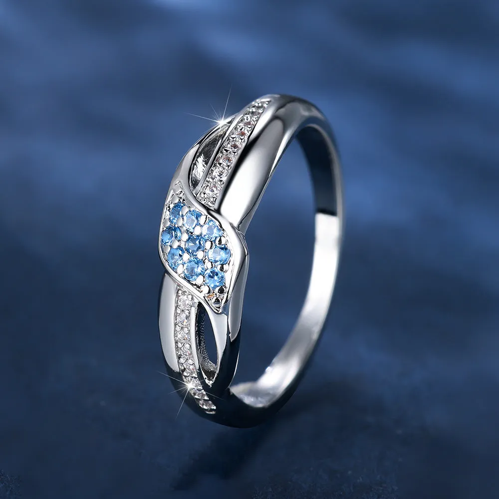 Women's ring with sea blue diamond edge inlay and white diamond leaf accents on white K plated copper band, simple geometric style