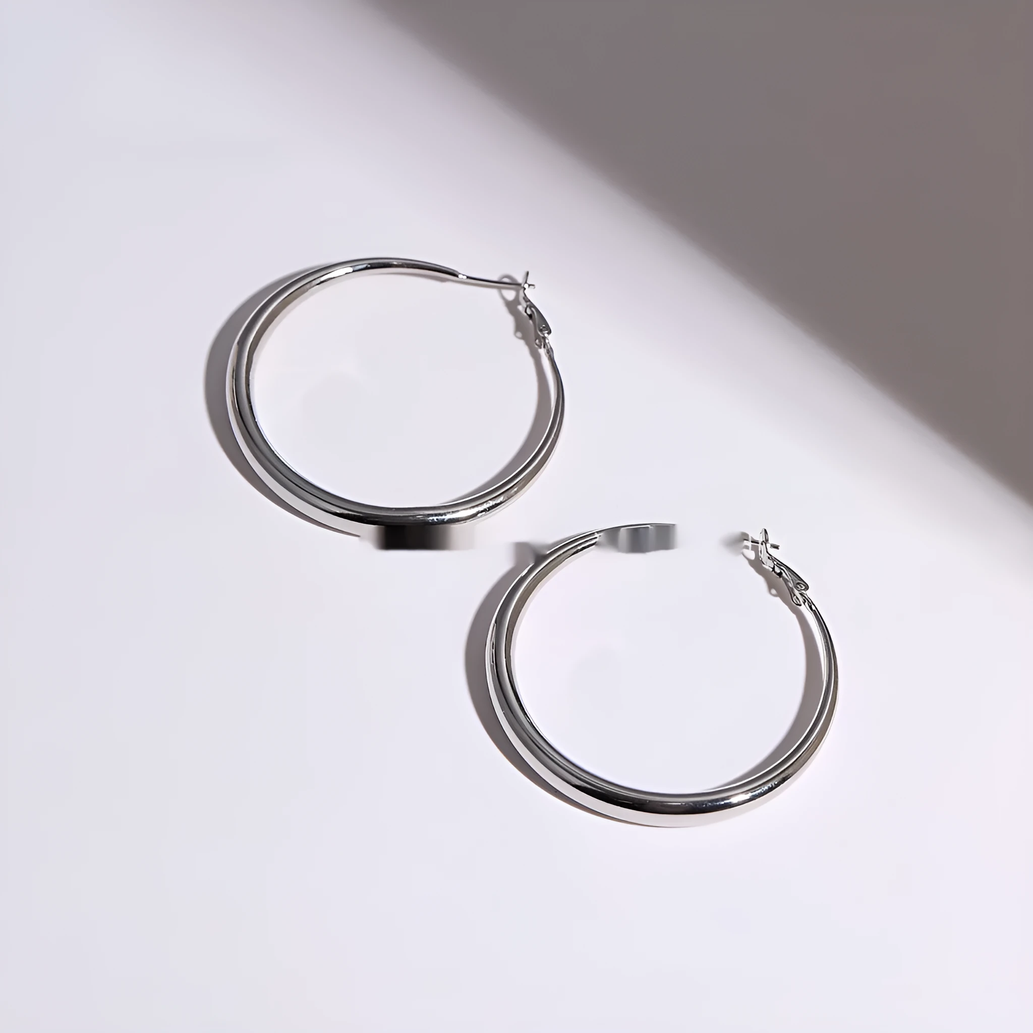 Silver needle big circle bracelet and earrings set with electroplated platinum finish on light background, three size options
