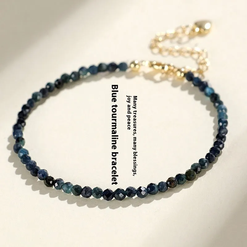 Close-up of a women's bracelet with 3mm blue tourmaline cut beads and silver-toned spacer beads on a wrist.