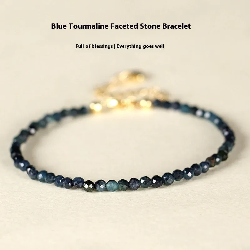 Close-up of a women's bracelet with 3mm blue tourmaline cut beads and silver-toned spacer beads on a wrist.