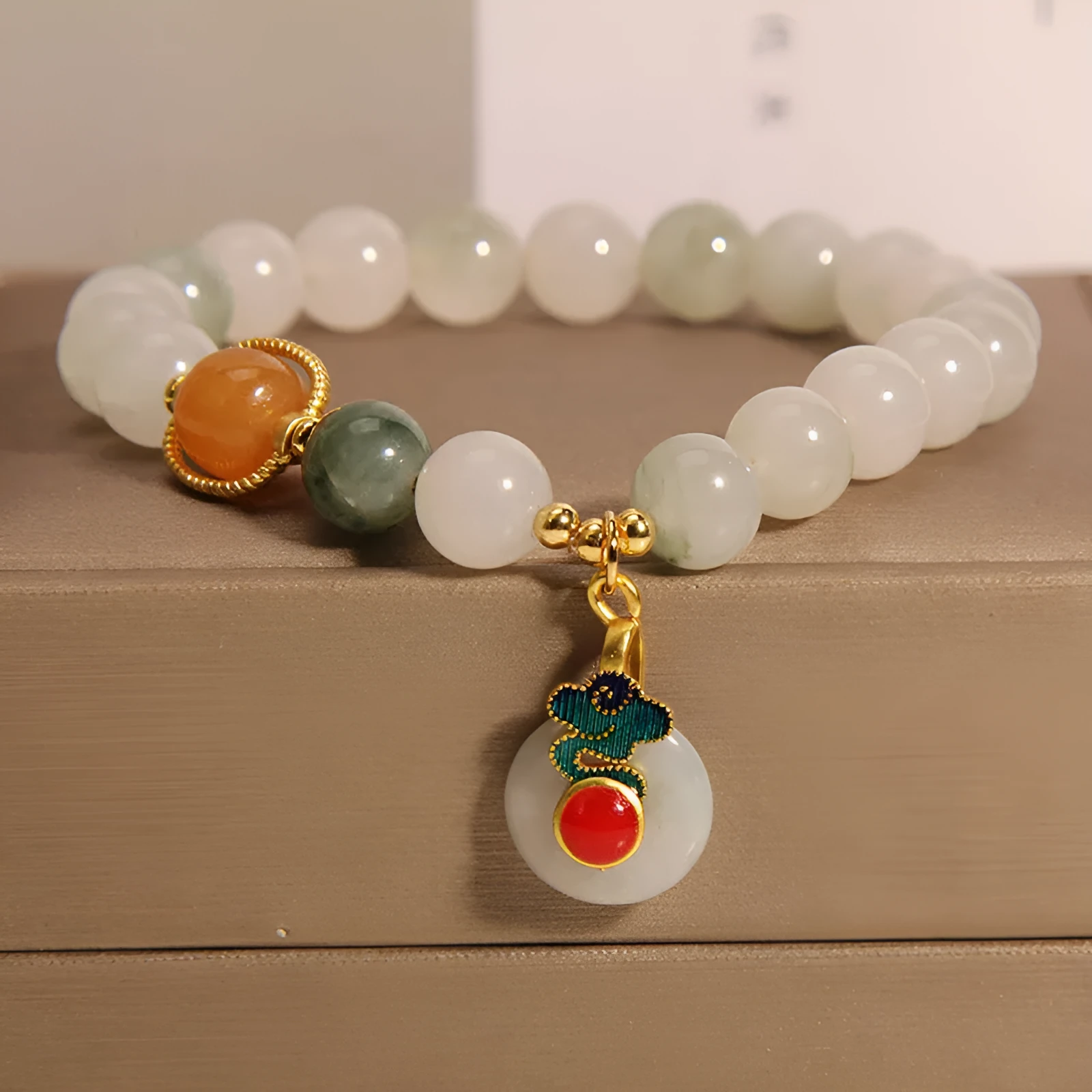 Close-up of a women's ice jade bracelet with carved Xiangyun design, pearl accents, and a jade sliding buckle.