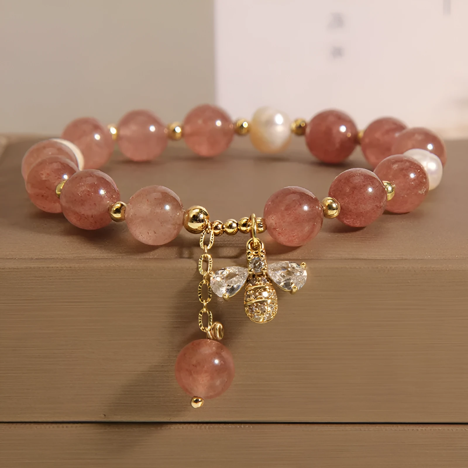 Women's bracelet with strawberry quartz beads, freshwater pearls, and zircon crystals on gold-tone clasp
