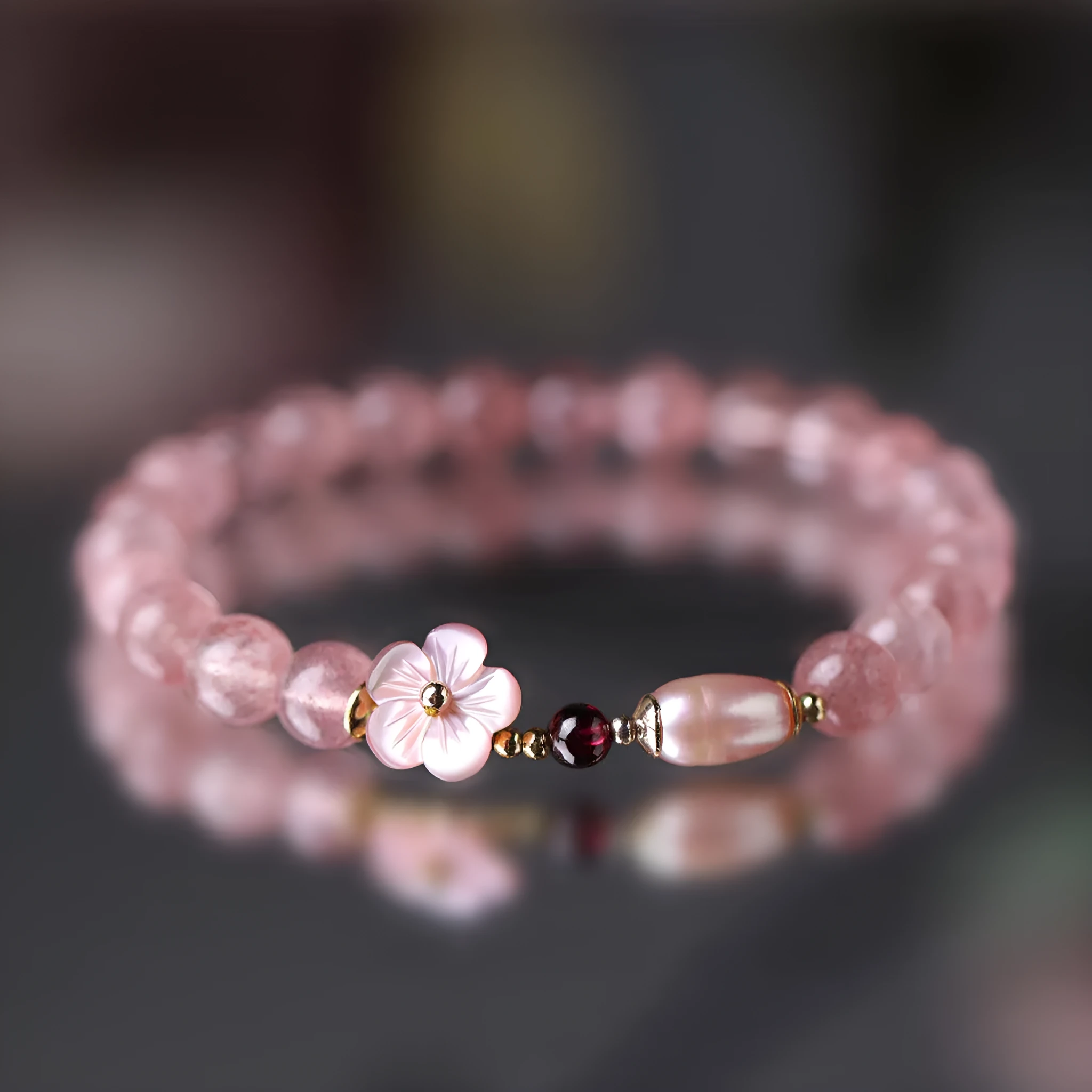 Women's strawberry quartz crystal bracelet with peach blossom flower bead design on wrist
