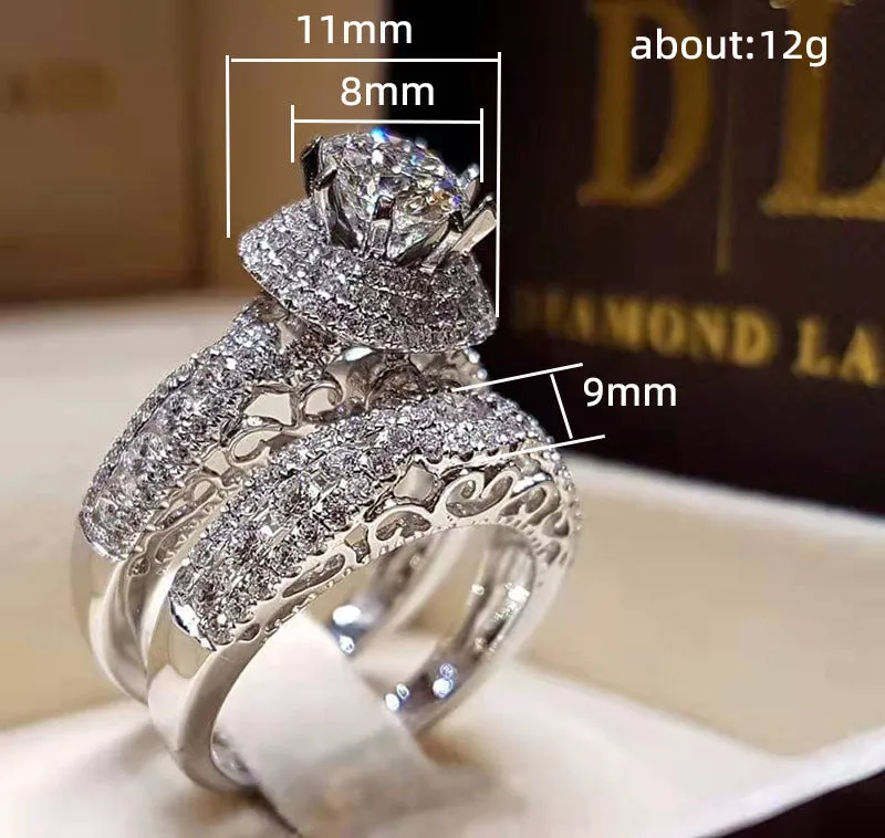 Pair of white gold colour copper couple rings with inlaid zircon stones, geometric U-shaped design on white background