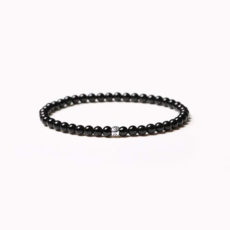 Geometric unisex bracelet with 4mm black agate, blue san, and obsidian beads on a wrist.