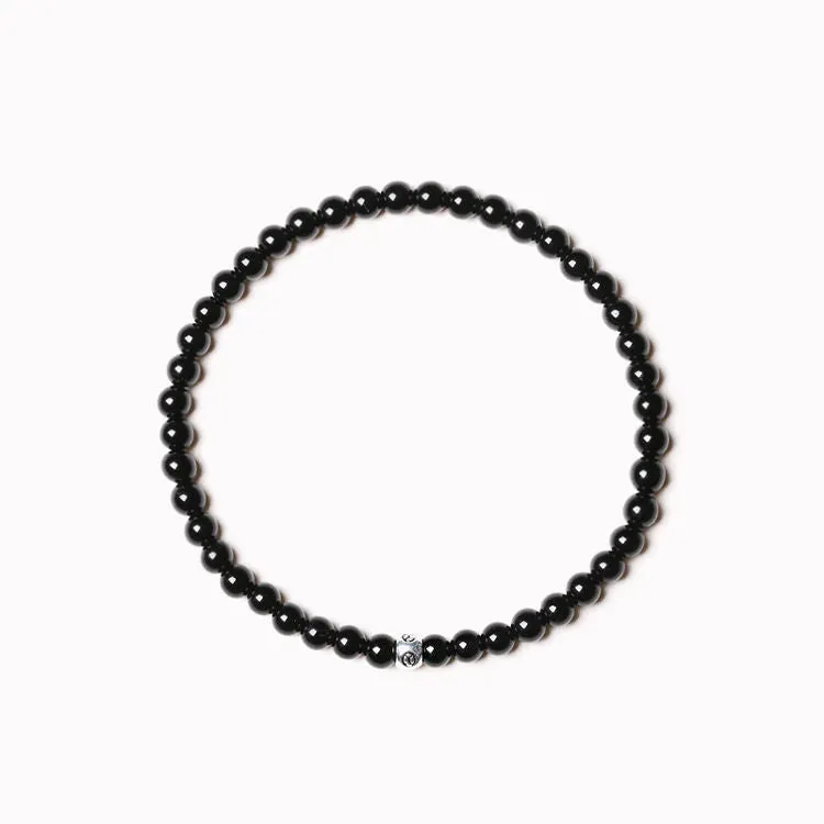 Geometric unisex bracelet with 4mm black agate, blue san, and obsidian beads on a wrist.