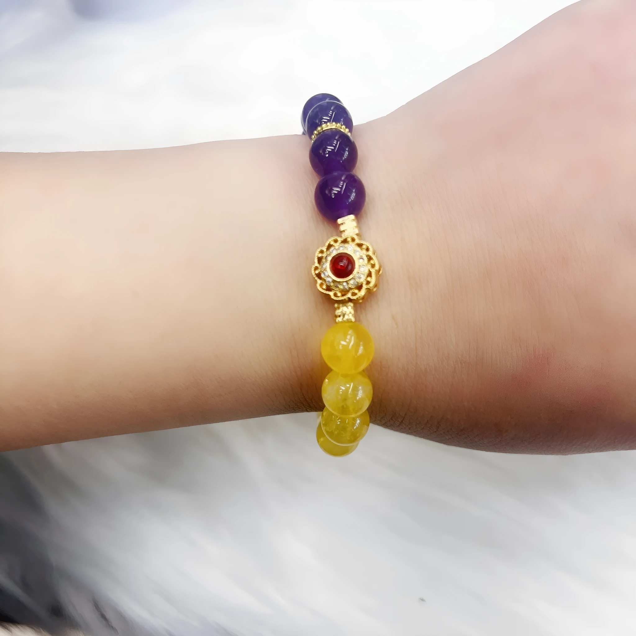 Handmade women's bracelet with yellow and purple amethyst crystals on wrist