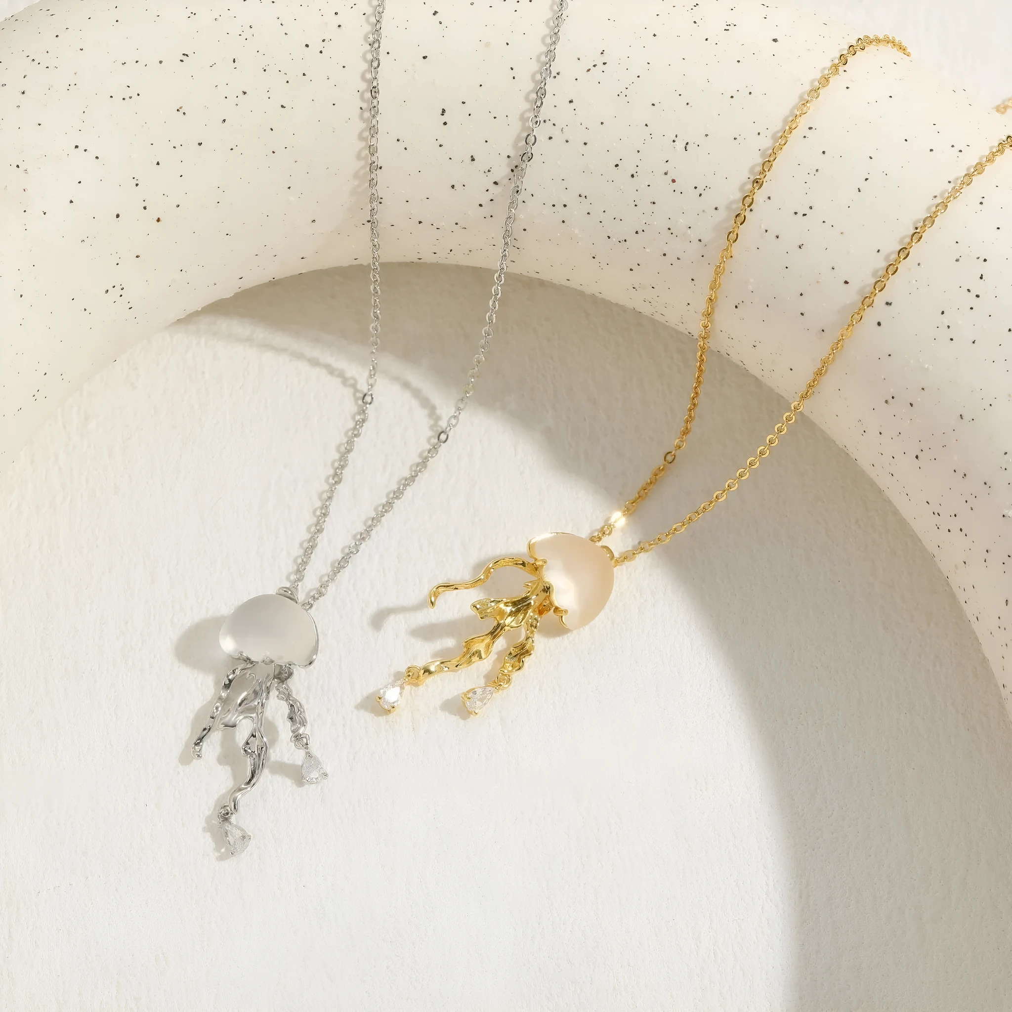 18K gold titanium steel openwork jellyfish pendant on silver O-ring chain against white background