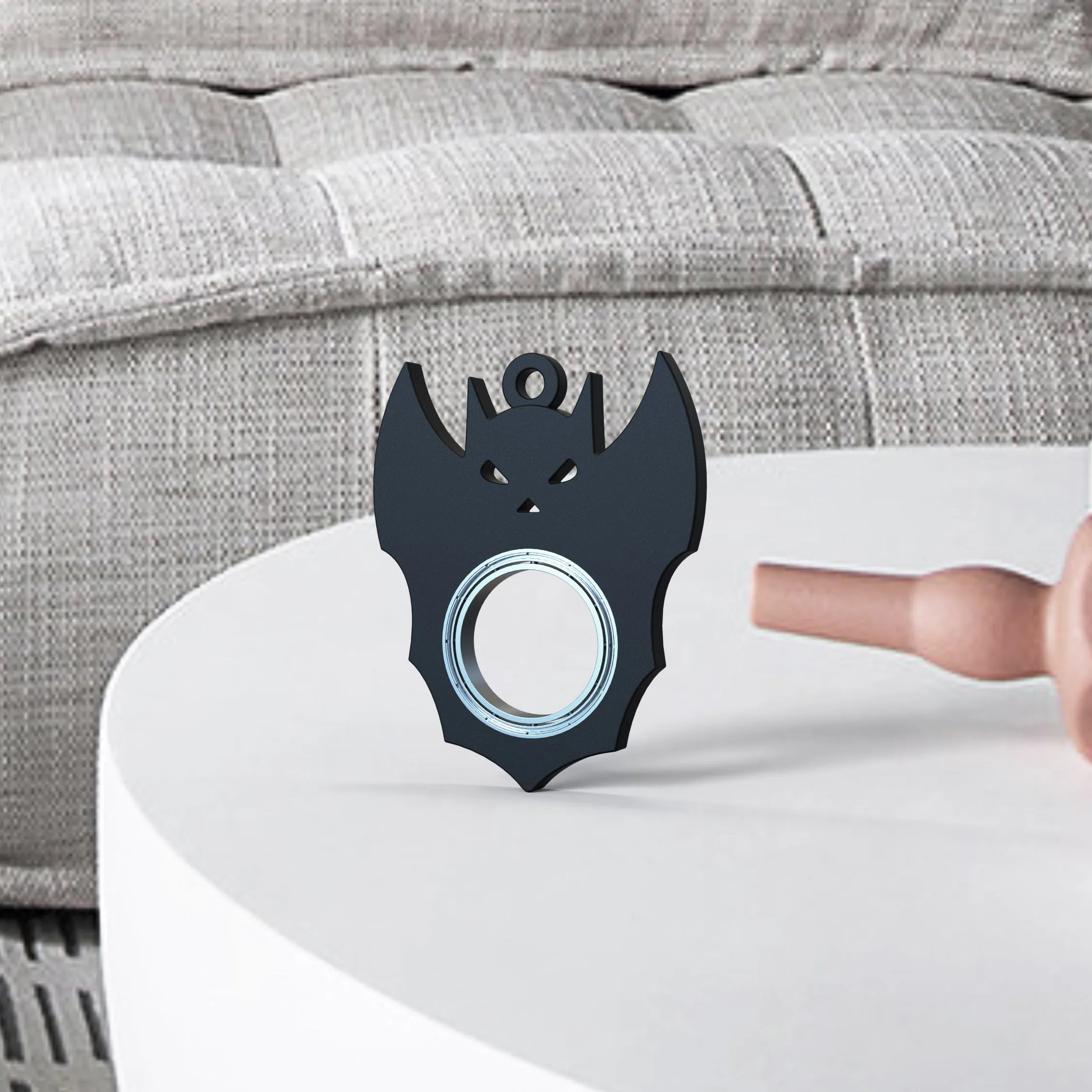 Black plastic Halloween bat demon ghost fidget spinner keychain with bottle opener on a dark background