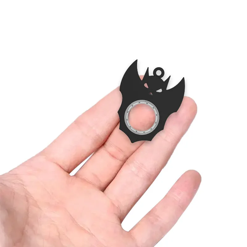 Black plastic Halloween bat demon ghost fidget spinner keychain with bottle opener on a dark background