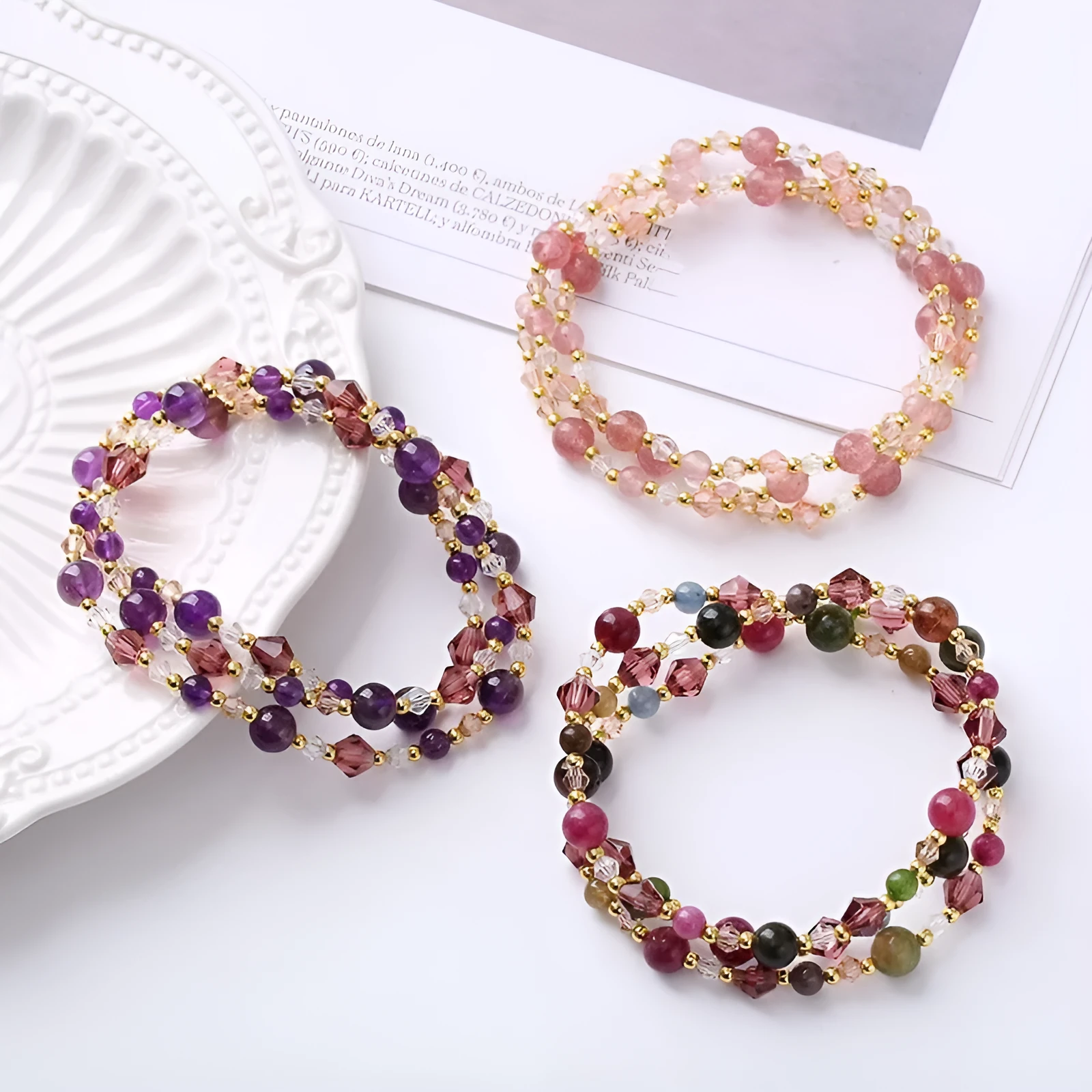 Women's three-ring crystal bracelet with tourmaline, strawberry quartz, and amethyst beads on adjustable rope.