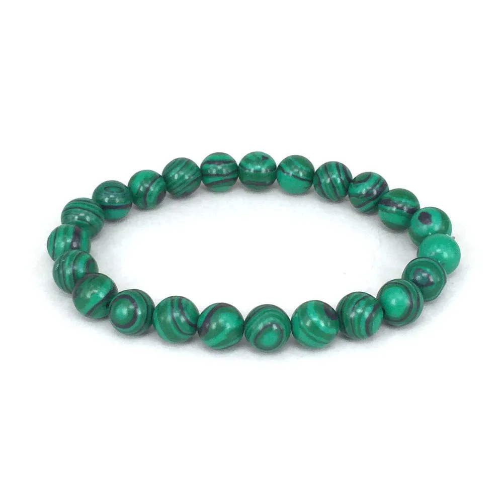 Malachite green and black matte 8mm round bead elastic strand bracelet on a neutral background