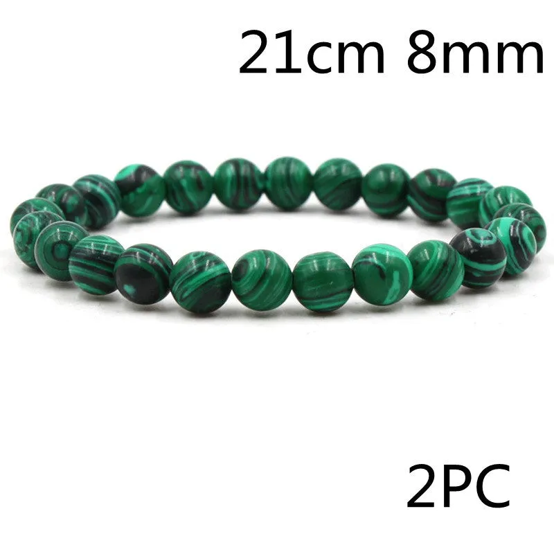 Malachite green and black matte 8mm round bead elastic strand bracelet on a neutral background