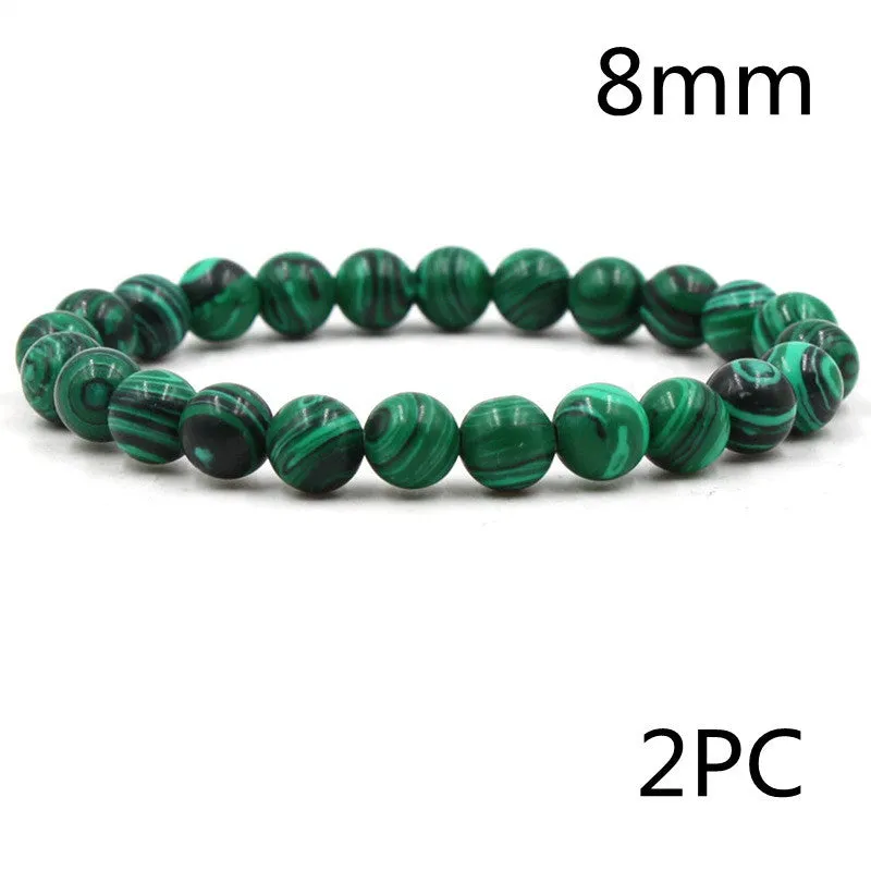 Malachite green and black matte 8mm round bead elastic strand bracelet on a neutral background