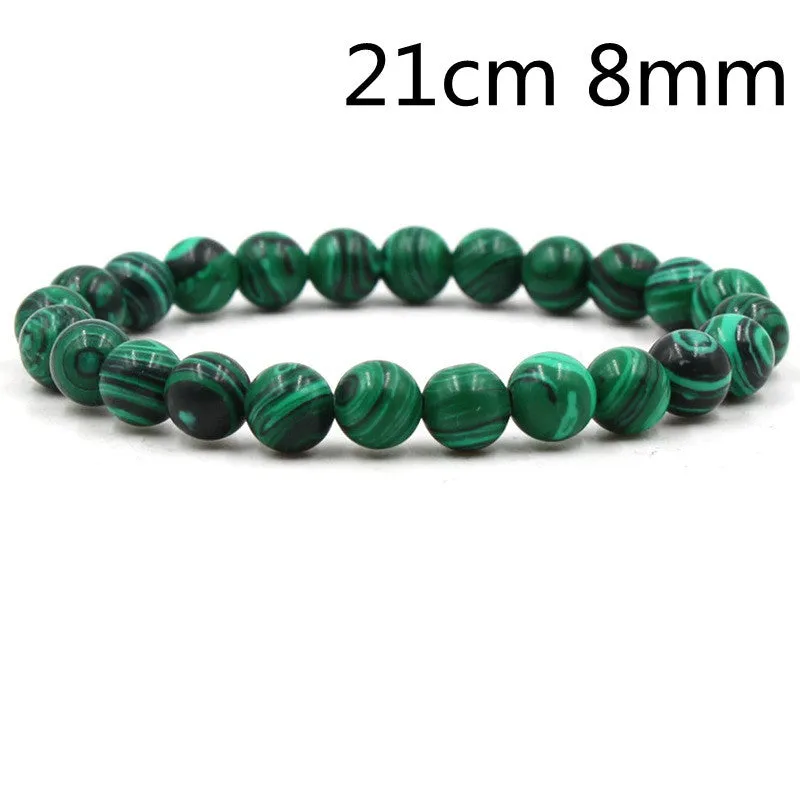 Malachite green and black matte 8mm round bead elastic strand bracelet on a neutral background