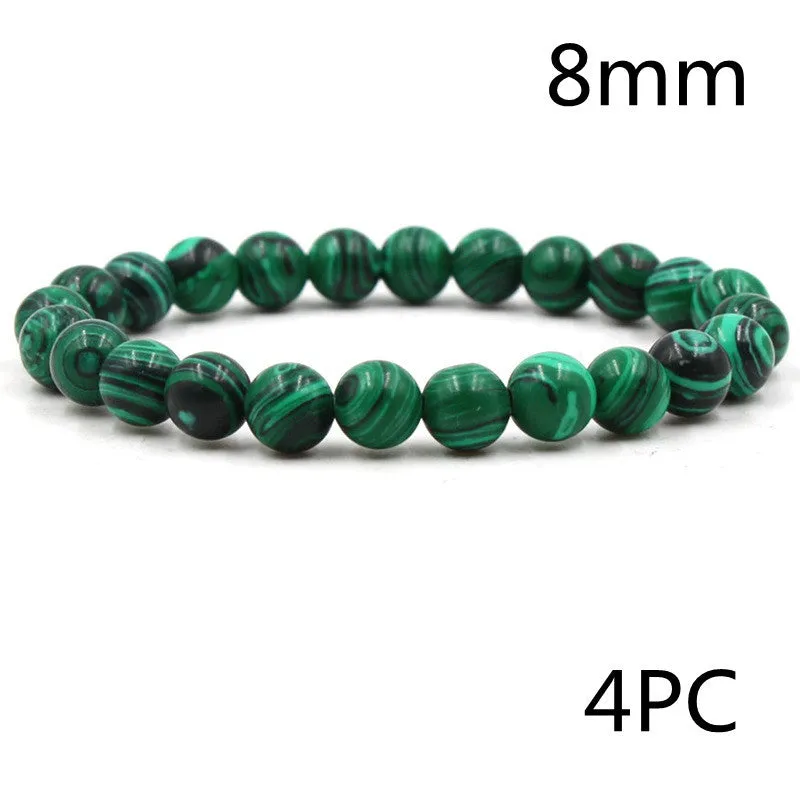 Malachite green and black matte 8mm round bead elastic strand bracelet on a neutral background
