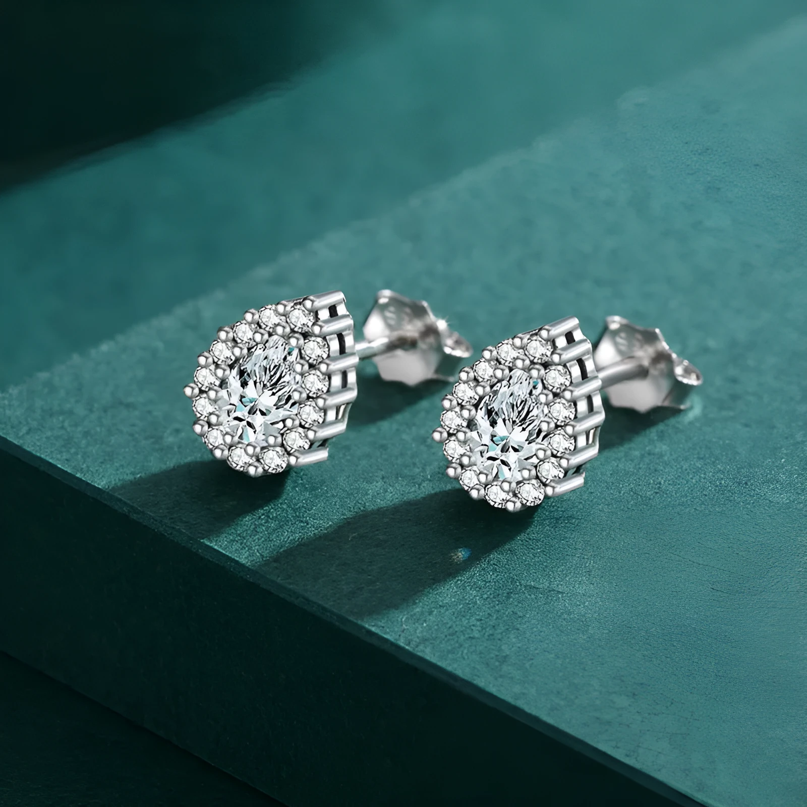Women's silver water drop shaped ear studs made from 925 sterling silver with diamond treatment