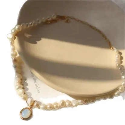 Gold necklace with irregular baroque pearl beads and a round copper pendant on string