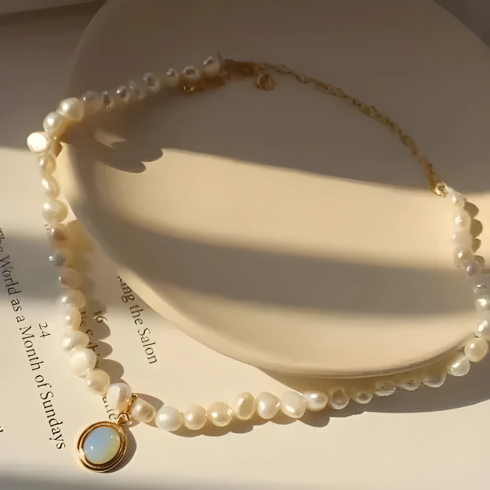 Gold necklace with irregular baroque pearl beads and a round copper pendant on string