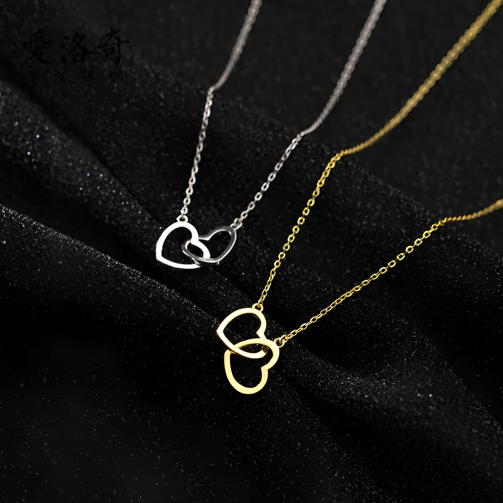 Double heart interlocking titanium steel necklace in gold on a white background with cross chain substyle